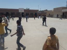 ساحة مدرسة تونسية خلال فترة الاستراحة، حيث يتحرك المتعلمون بحرية في فضاء آمن يدعم التوازن النفسي ضمن اليوم الدراسي.